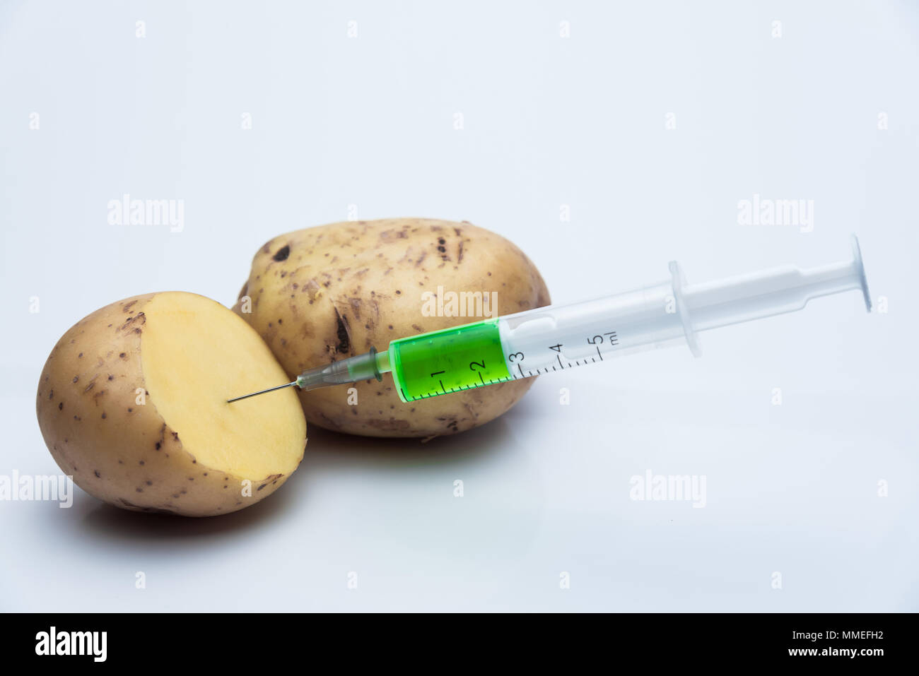Syringe with harmful contents in potatoes Stock Photo Alamy
