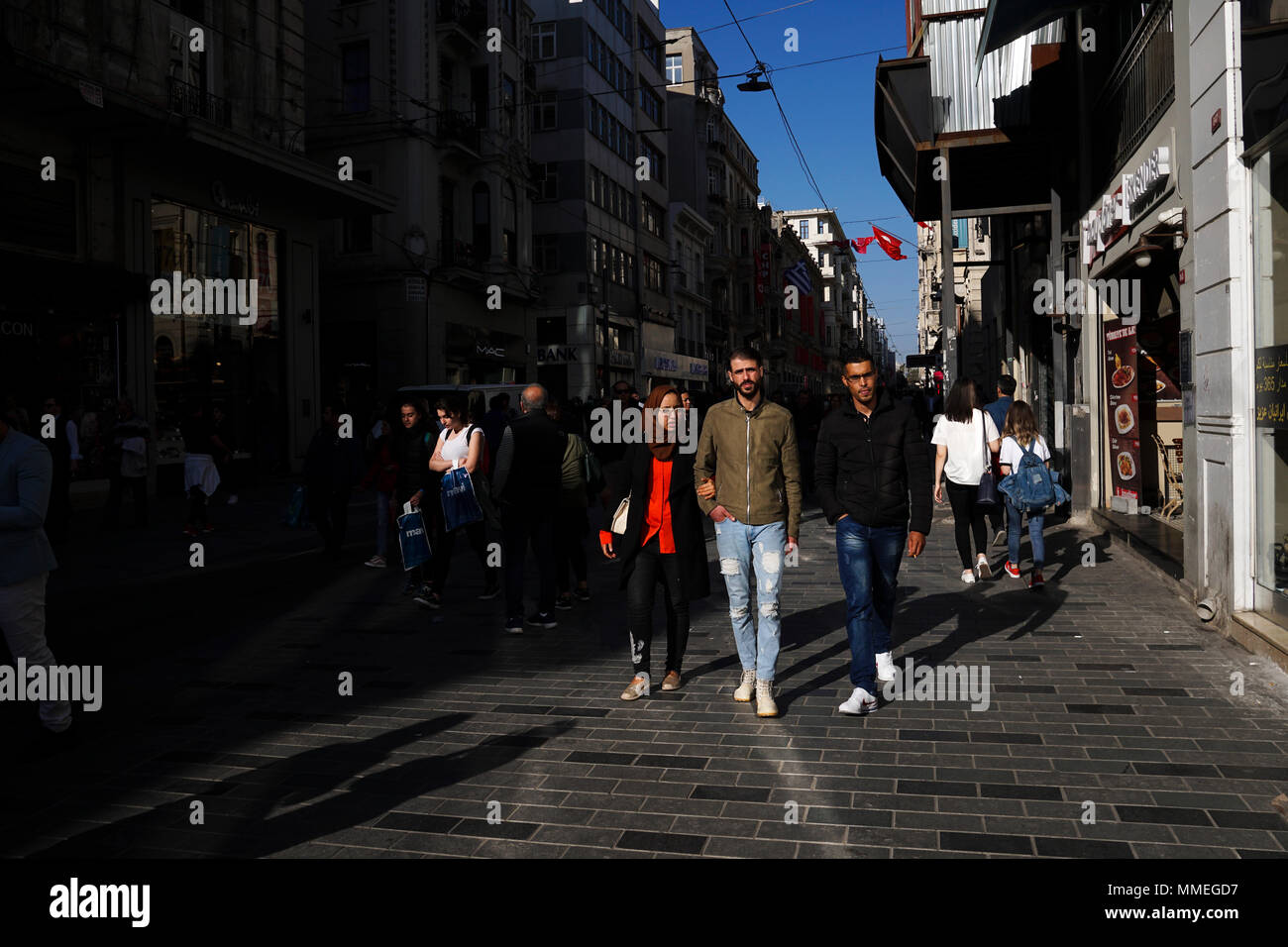 Istanbul, Turkey - April 19, 2018: Arap ethnicity tourists are walking at The Istiklal Street, Beyoglu in a sunny springtime day. There are many store Stock Photo