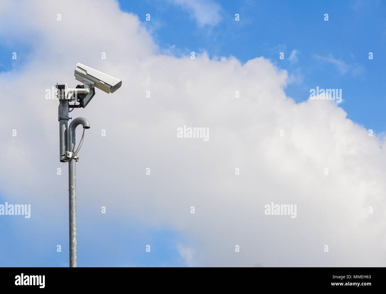 Security camera install corner outside of building with blue sky
