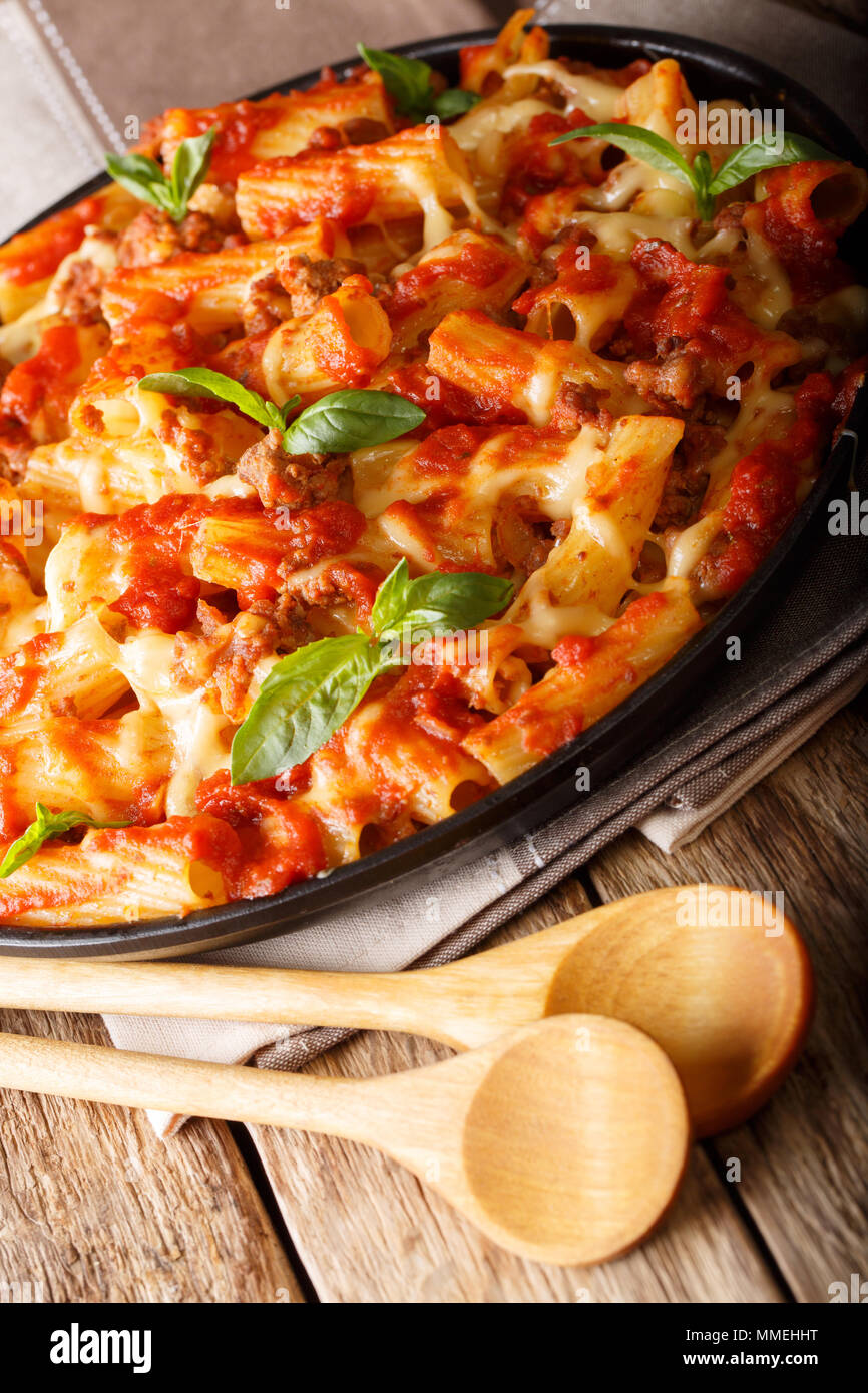 Pasta ziti with bolognese sauce and cheese close-up on the table. vertical, rustic style Stock Photo