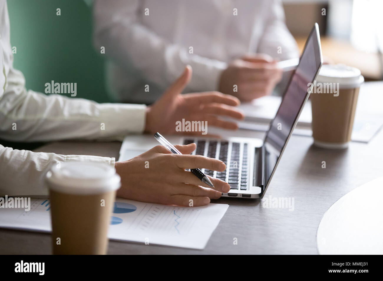 Businesswoman using laptop presenting project report at business Stock Photo