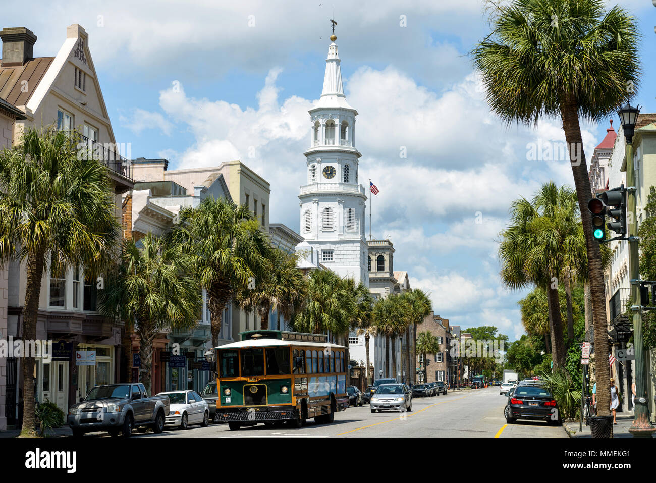 Downtown Charleston - A Charleston DASH trolley, part of CARTA Transit System, driving on historic Broad street in front of St Michaels Church. SC, US Stock Photo