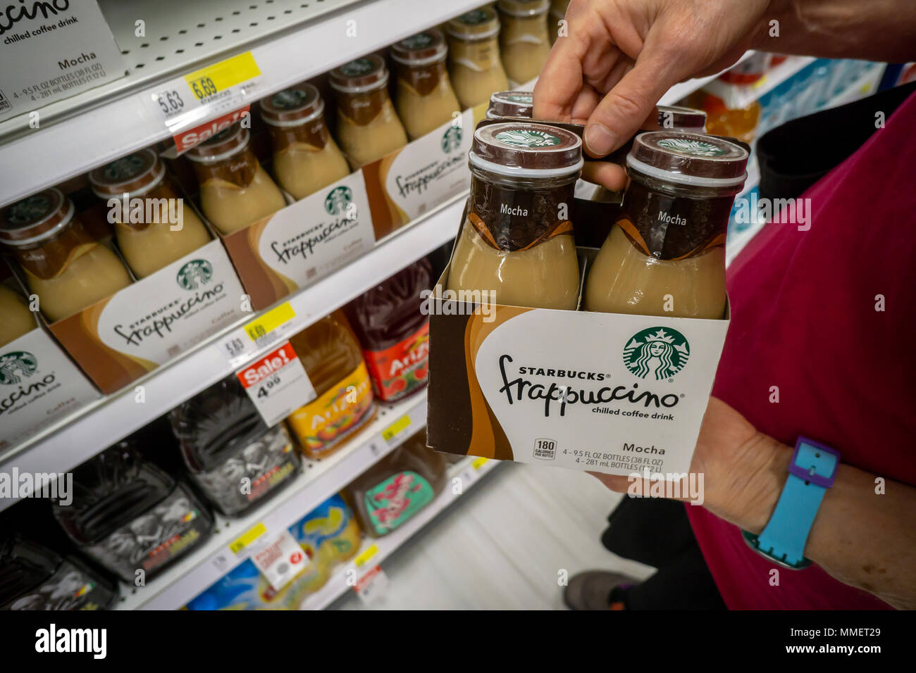 A shopper chooses Starbucks Frappuccino coffee in a supermarket in New York on Friday, May 4, 2018. NestlŽ is reported to be in talks to purchase Starbucks' grocery business. The units that sell beans and drinks in supermarkets and groceries are involved and not any of the stores. NestlŽ is the world's largest packaged food company. (© Richard B. Levine) Stock Photo