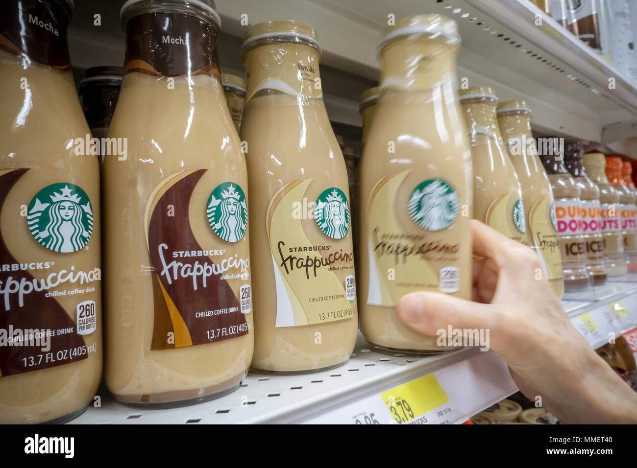 A shopper chooses Starbucks Frappuccino coffee in a supermarket in New York on Friday, May 4, 2018. Nestlé is reported to be in talks to purchase Starbucks' grocery business. The units that sell beans and drinks in supermarkets and groceries are involved and not any of the stores. Nestlé is the world's largest packaged food company. (© Richard B. Levine) Stock Photo