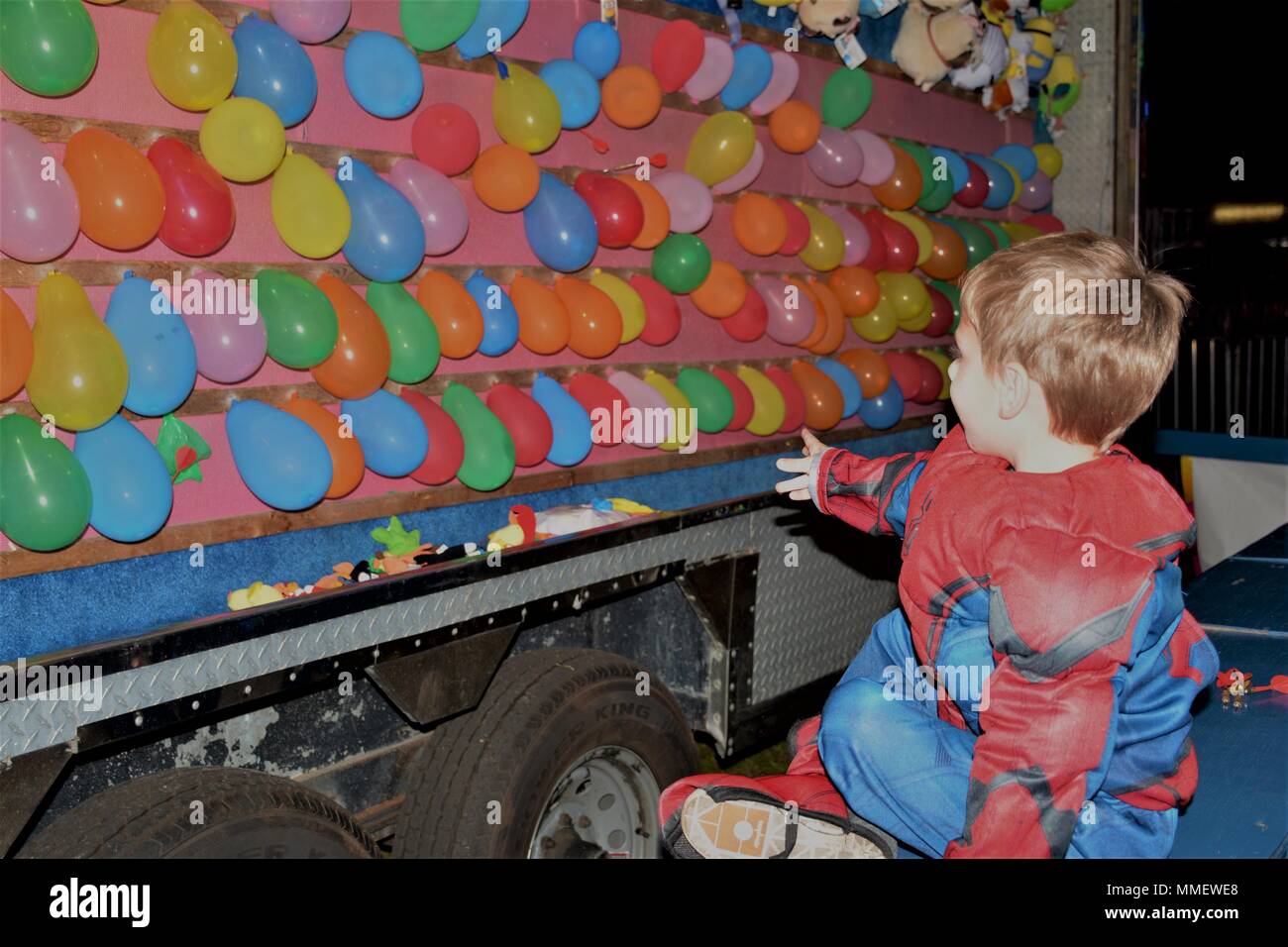 Spiderman” Aidyn throws a dart to pop a balloon during Fort Stewart's Fall  Fest Oct. 26 at Donovan Field. The host of the game assisted him and his  sister, Sara, in popping