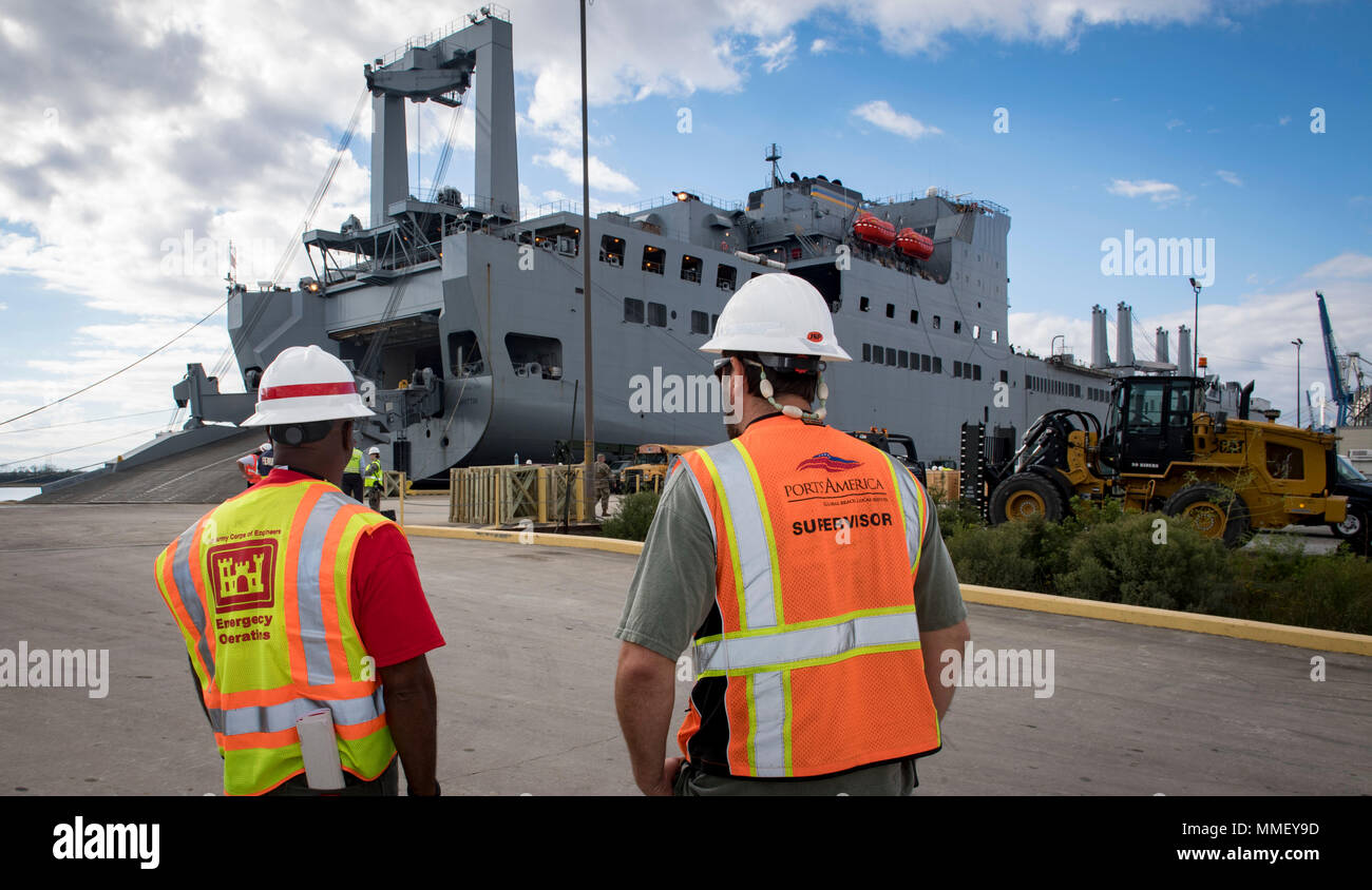Dennis Davis, left, U.S. Army Corps of Engineers, Charleston District transportation management specialist and Jason Metts, right, Cooper Ports America International Longshoremen's Association superintendent, look on as the USNS Brittin (T-AKR-305) with 855 pieces of equipment Oct. 28, 2017, at Joint Base Charleston-Weapons Station, S.C. The USNS Brittin will make several trips between Joint Base Charleston and Puerto Rico over the next few months. The first trip is bringing essentials such as food, water and vehicles to get aid to areas where mudslides have created access issues. Later delive Stock Photo