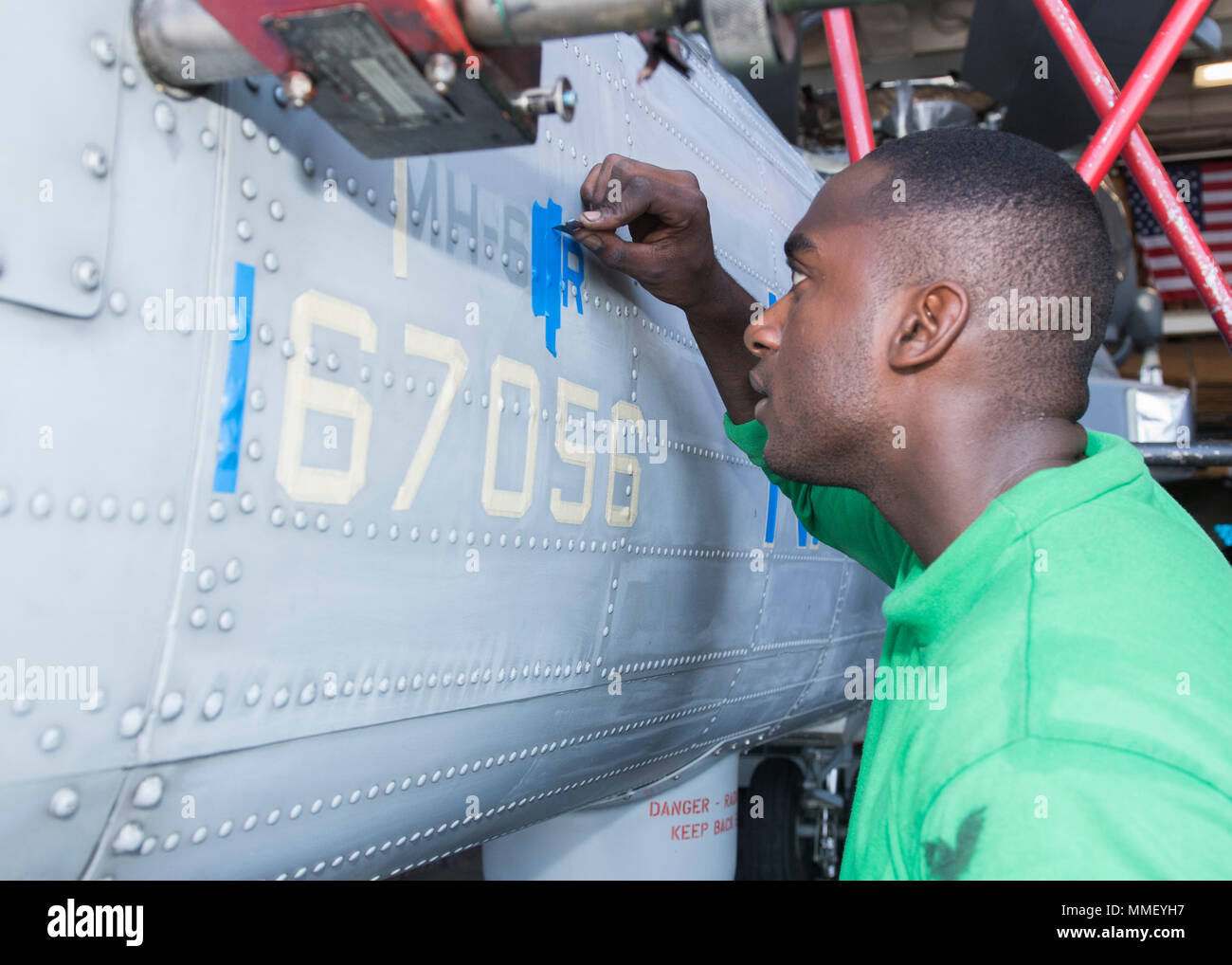 171028-N-MZ078-116 GULF OF ADEN (Oct. 28, 2017) Aviation Structural Maintenance Mechanic 2nd Class Melshi Miclisse, from Palm Bay, Fla., stencils an MH-60R Sea Hawk helicopter assigned to the 'Scorpions' of Helicopter Maritime Strike Squadron (HSM) 49 aboard the Ticonderoga-class guided-missile cruiser USS Lake Erie (CG 70). Lake Erie is deployed to the U.S. 5th Fleet area of operations in support of maritime security operations to reassure allies and partners, and preserve the freedom of navigation and the free flow of navigation and the free flow of commerce in the region. (U.S. Navy photo b Stock Photo
