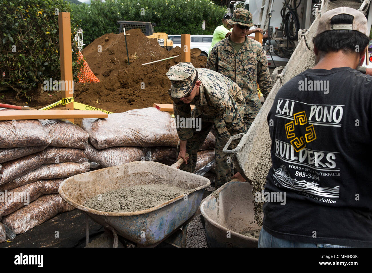 Lance Cpl. John Lewis moves a wheelbarrow full of cement during a