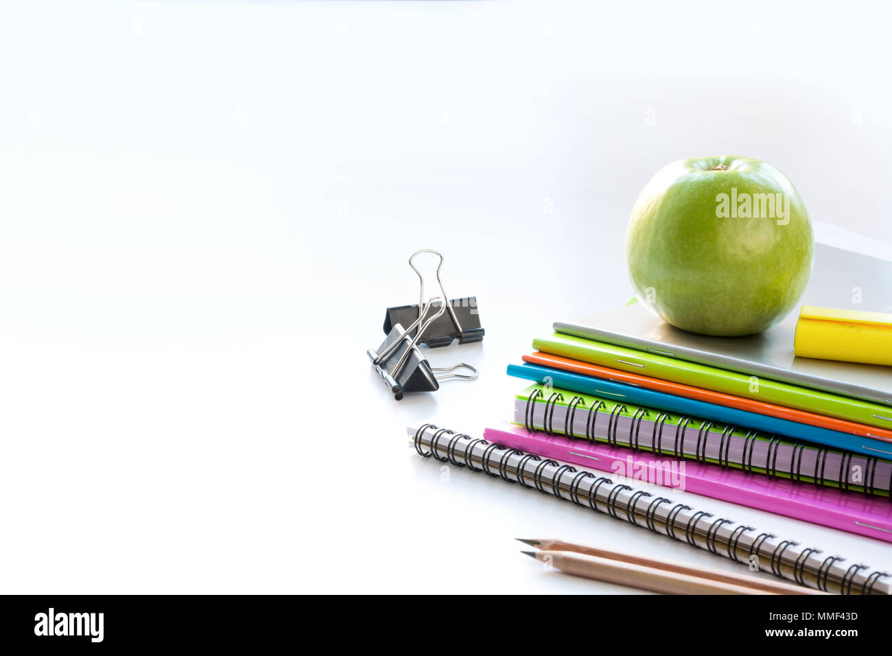 Colorful school supplies, book, apple on white. Close up. Back to school. Stock Photo