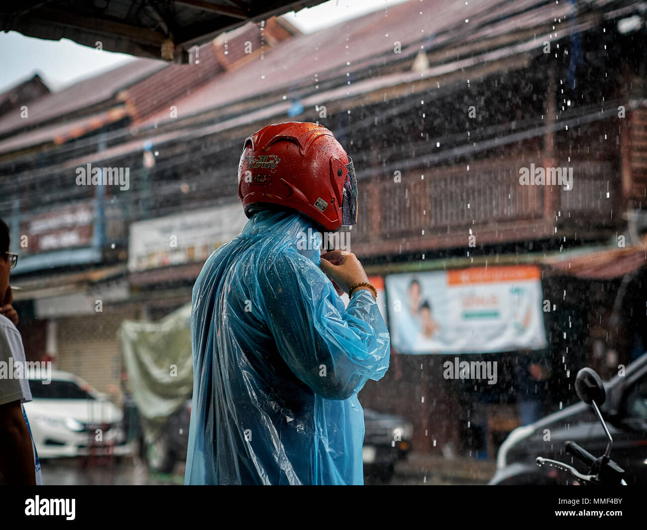 Rain.  motorbike rider in torrential rainfall. Thailand monsoon season. Southeast Asia. Stock Photo