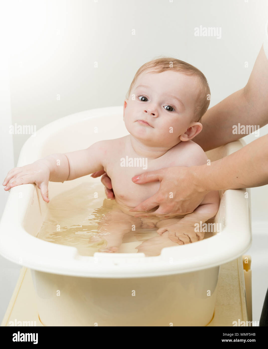 Cute 10 months old baby boy sitting in plastic bathtub Stock Photo Alamy