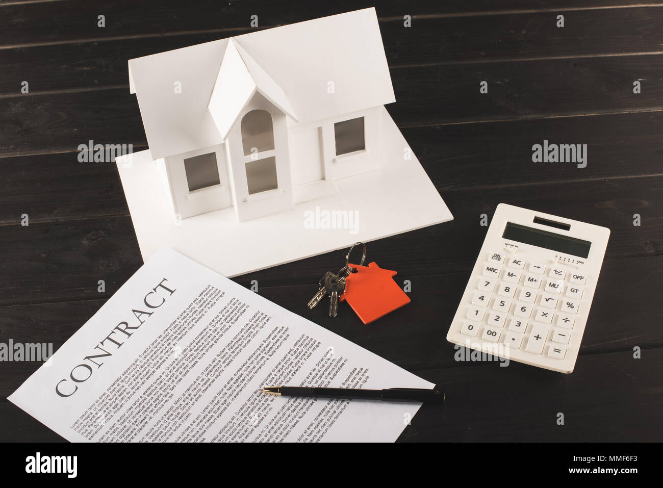 house buying concept with contract, keys, calculator and maquette over wooden table Stock Photo