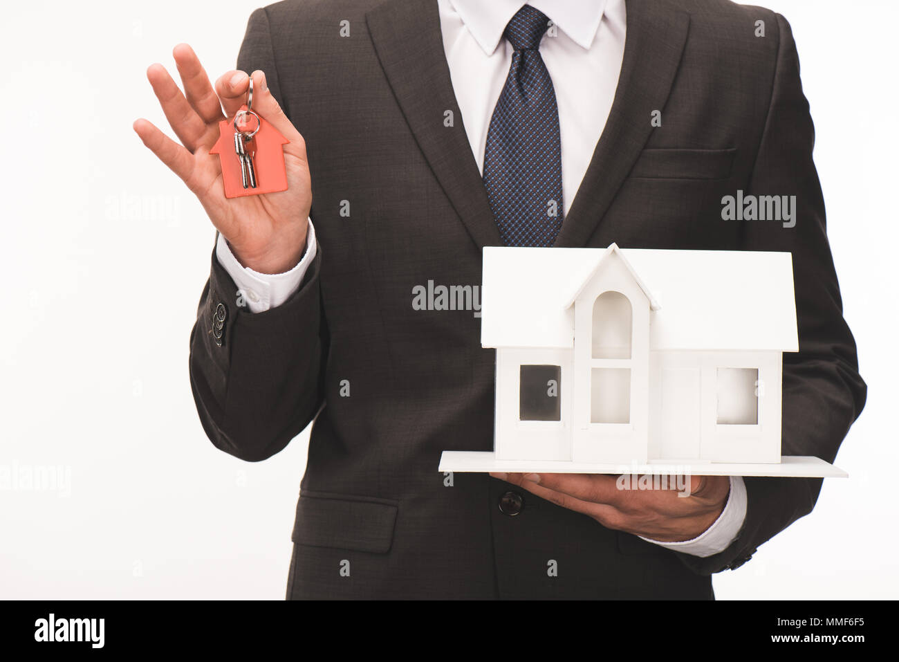 cropped image of man holding maquette of house with key isolated on ...