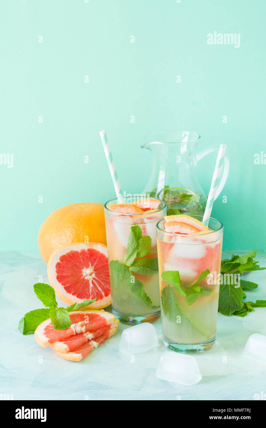 Refreshment grapefruit cocktail with mint on mint color background