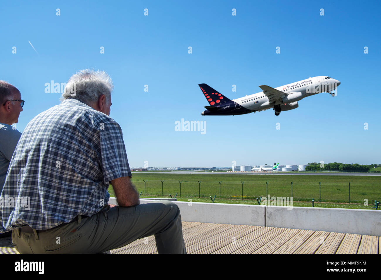 Plane spotters on aircraft spotting platform watching airplane from Brussels Airlines taking off from runway at Brussels Airport, Zaventem, Belgium Stock Photo