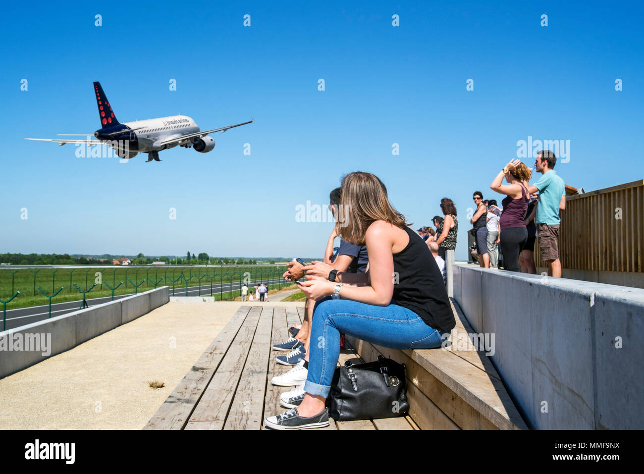 Plane spotters on aircraft spotting platform watching airplane from Brussels Airlines taking off from runway at Brussels Airport, Zaventem, Belgium Stock Photo