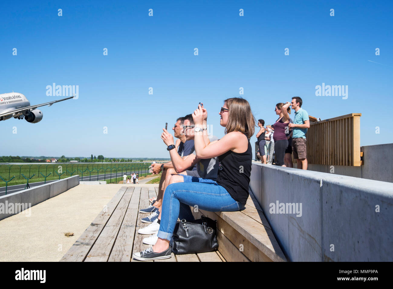 Plane spotters on aircraft spotting platform watching airplane from Brussels Airlines taking off from runway at Brussels Airport, Zaventem, Belgium Stock Photo