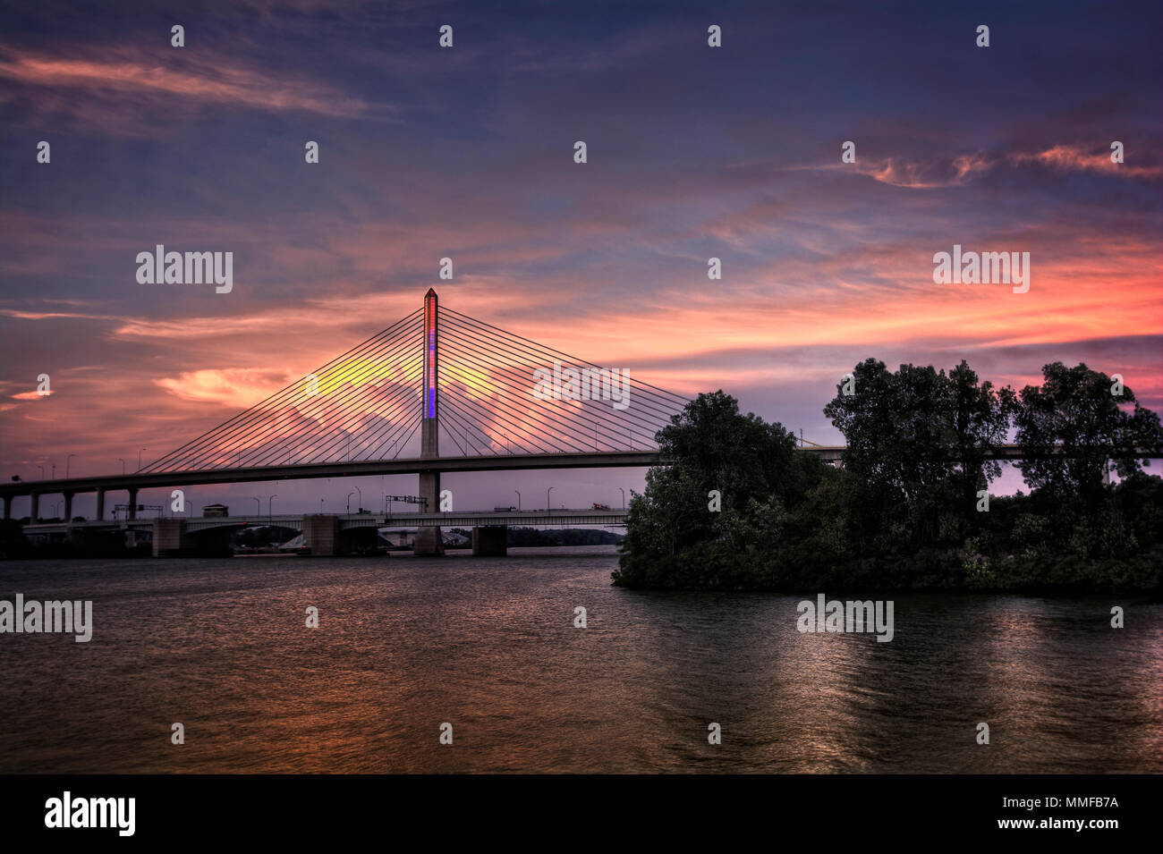 Sunset view of the Veterans' Glass City Skyway bridge in Toledo Ohio.  The bridges center pylon is lit up with LED lighting in red white and blue colo Stock Photo