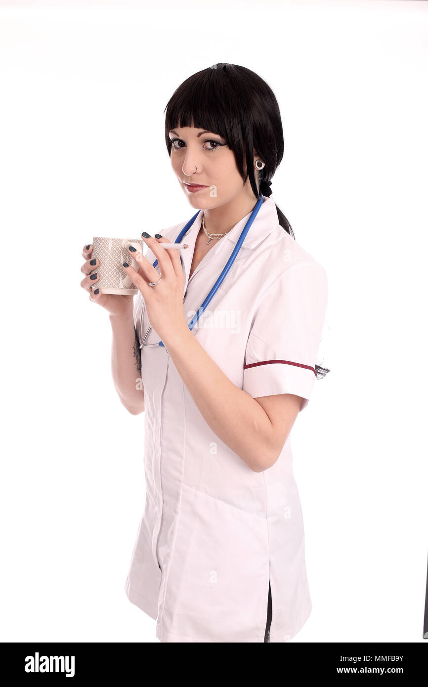 May 2015 - Young nurse taking a break, a coffee and a cigarette. Stock Photo