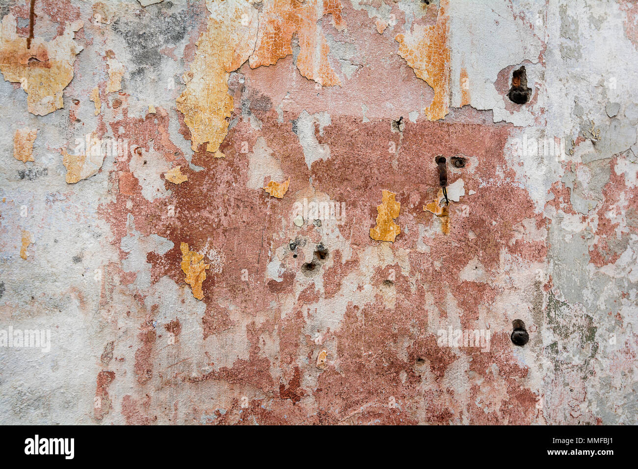 Photo of a colorful old decaying brick wall with peeling paint and stucco. Great for a background image or a texture. Stock Photo