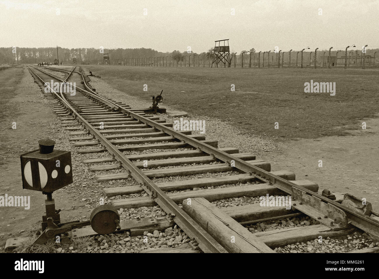 AUSCHWITZ, POLAND, OCTOBER 12, 2013: Rail of railroad at concentration camp at Auschwitz Birkenau KZ, black white and beige duplex processing photography with image noise effect, Poland Stock Photo