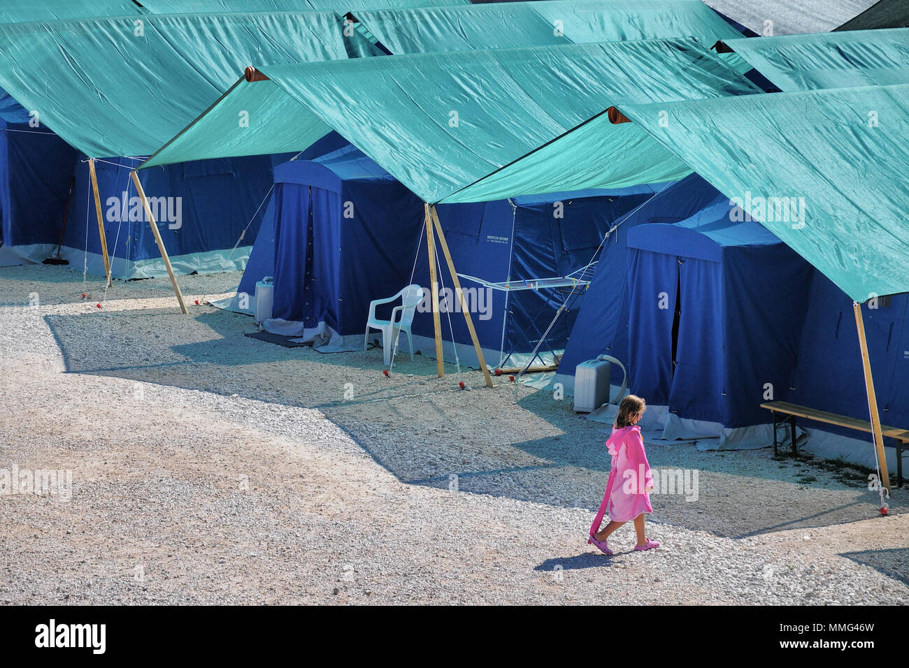 Earthquake refugees tent camp with lonely child walking Aquila Italy August 2009 Stock Photo