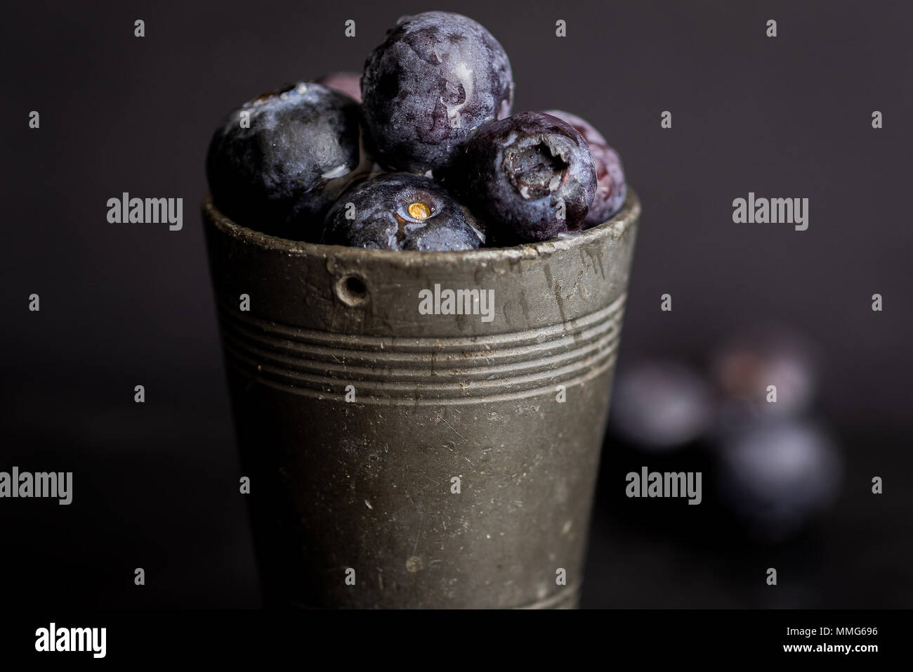 Close up of blueberries in a metal cup--dark food Stock Photo
