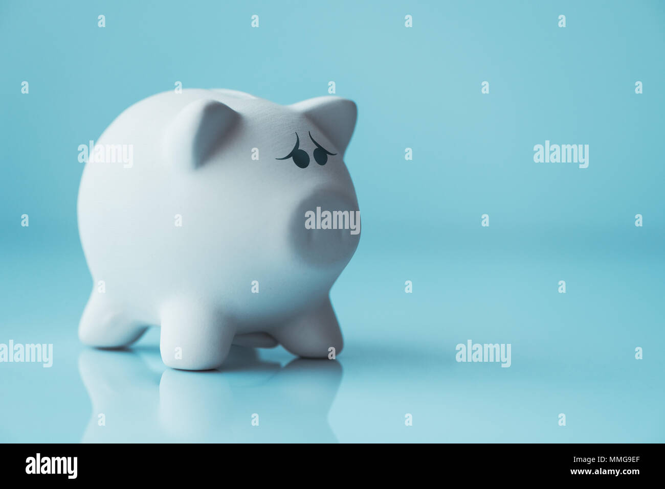 Unhappy piggy coin bank for investment and savings downturn concept Stock Photo