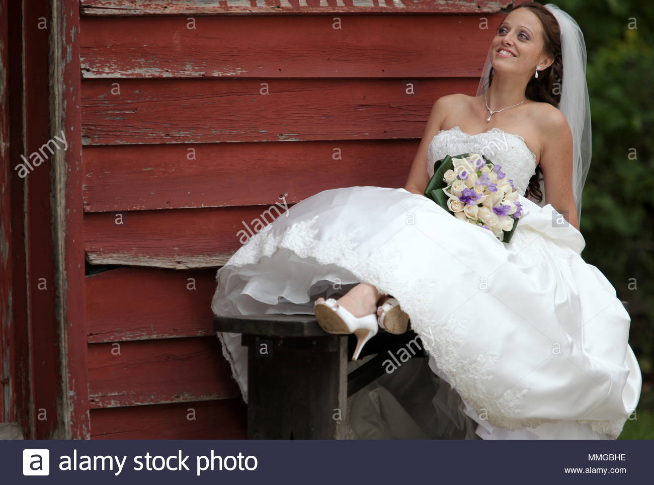 A Bride In A Traditional White Wedding Dress Holding A Bouquet Of