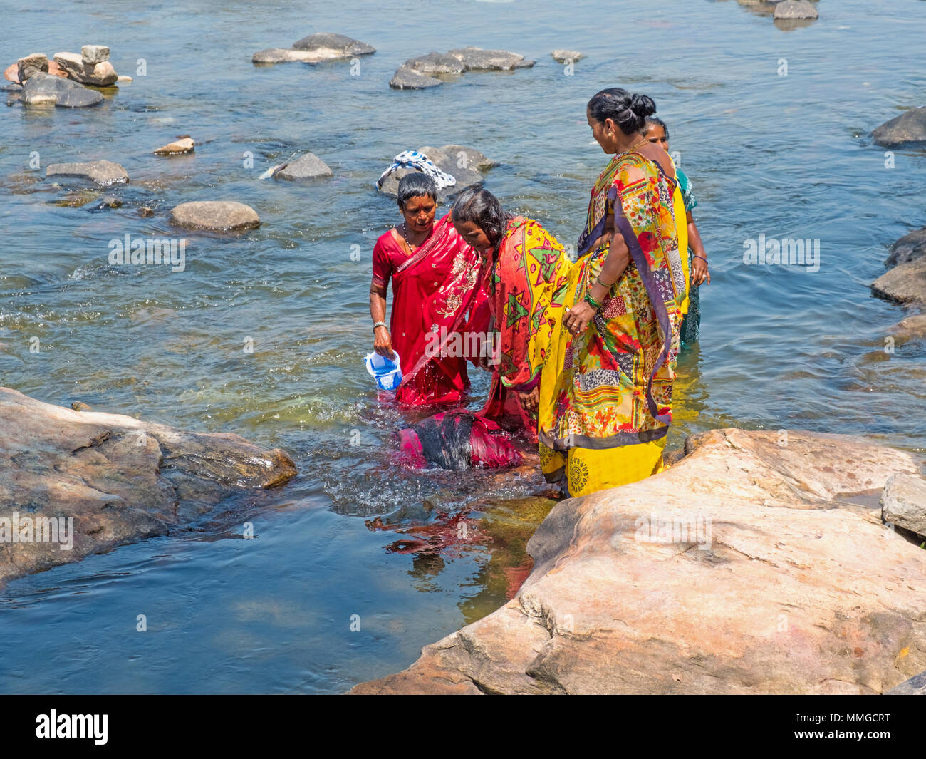 Shrirangapattan, India - March 2, 2018: Hindu pilgrims performing a cleansing ritual in the sacred river Kaveri Stock Photo