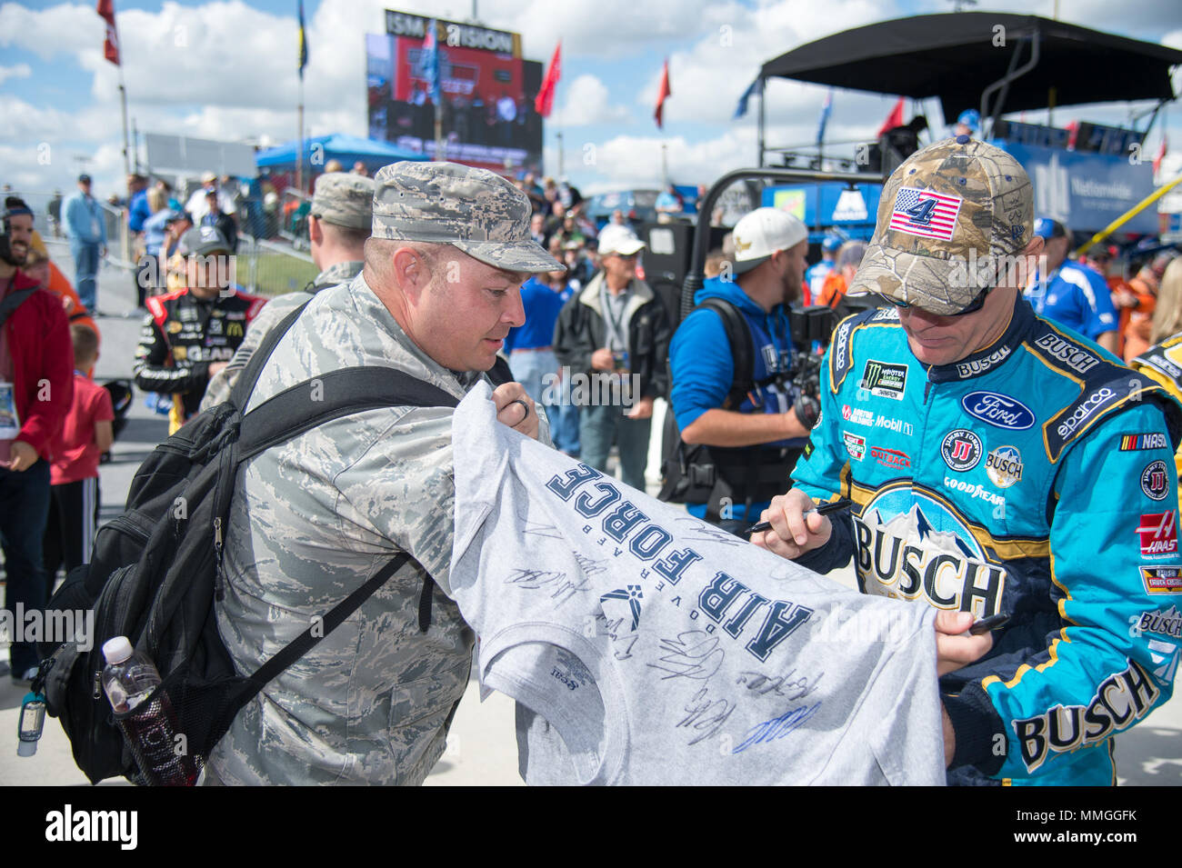 Kevin Harvick, driver of the No. 4 Ford Fusion, autographs a t-shirt for Tech. Sgt. Steven Auer, 436th Operations Support Squadron air traffic control ops supervisor, before the Apache Warrior 400 race Oct. 1, 2017, at Dover International Speedway, Dover, Del. Auer was a participant of the Troops to Tracks program, which treats service members, veterans and military families to special VIP access at NASCAR races. (U.S. Air Force photo by Mauricio Campino) Stock Photo