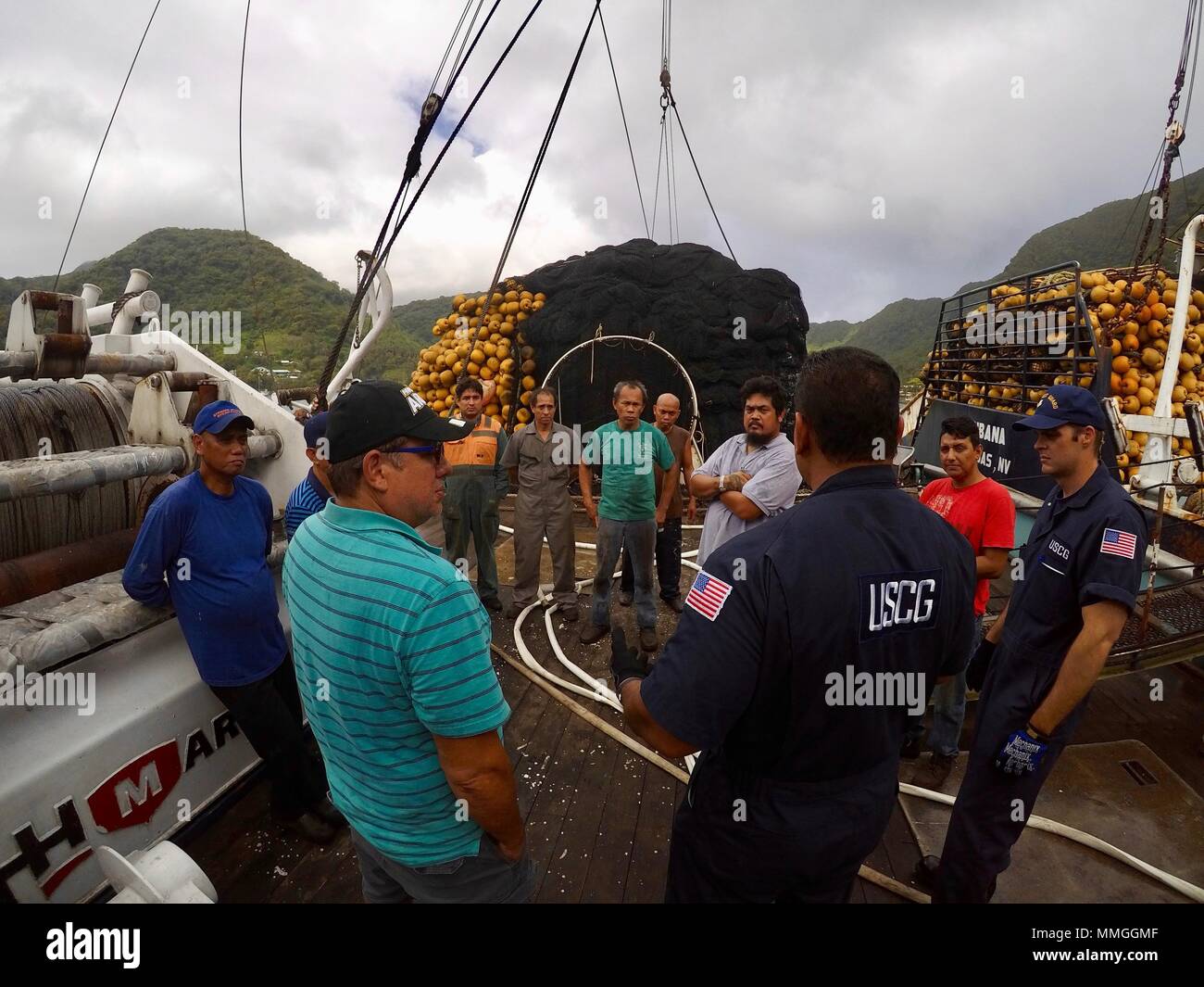 Petty Officer 1st Class Jared Bohler, Frank Thomsen and Lt. Tanner Stiehl,  all with Marine Safety Detachment American Samoa, discuss safety drills  being held aboard the 190-foot U.S.-flagged tuna purse seiner Raffaello