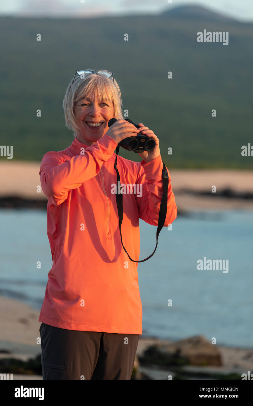 Woman with binoculars on a beach in the Galapagos Islands, Ecuador
