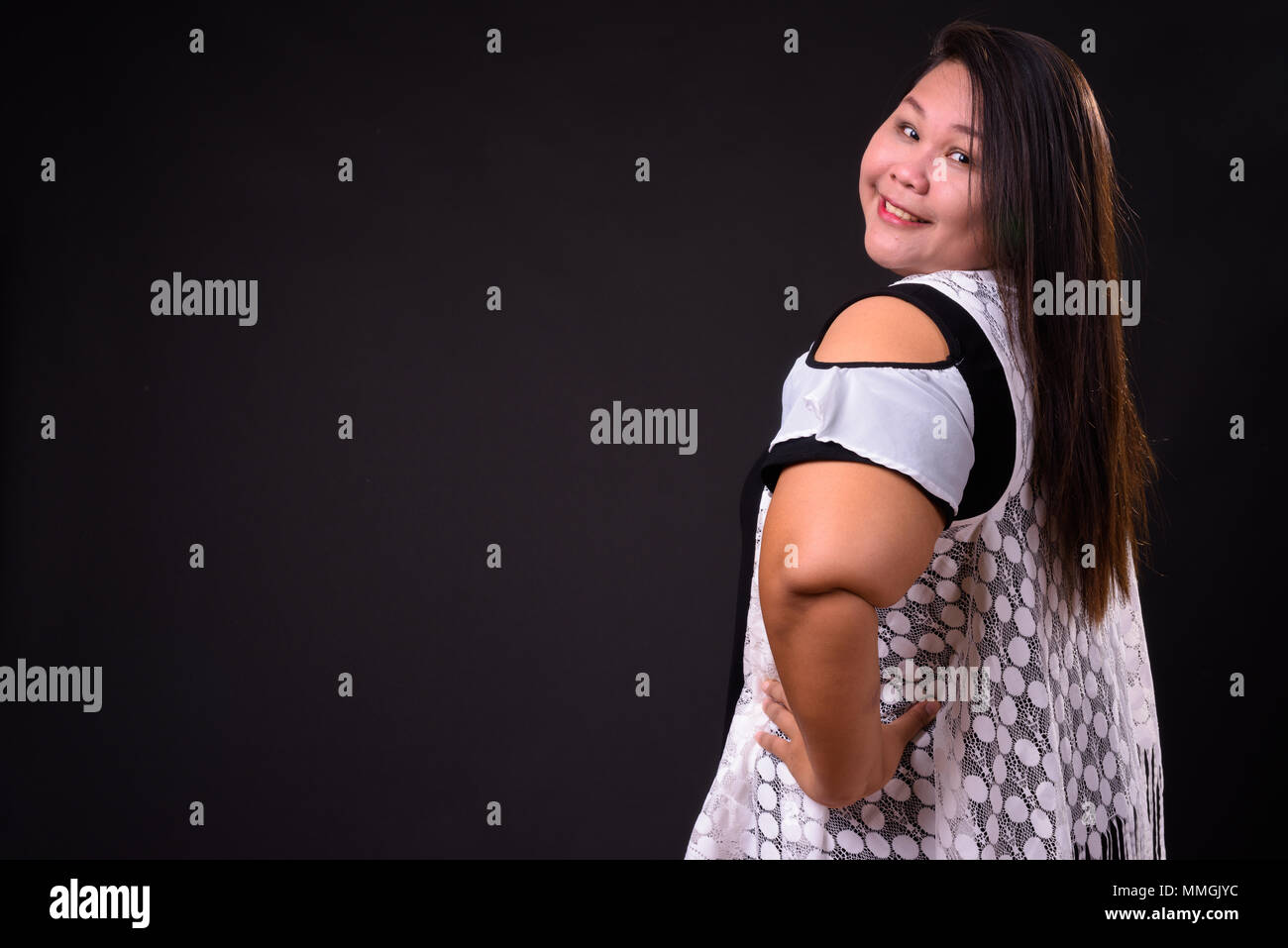 Beautiful overweight Asian woman against black background Stock Photo