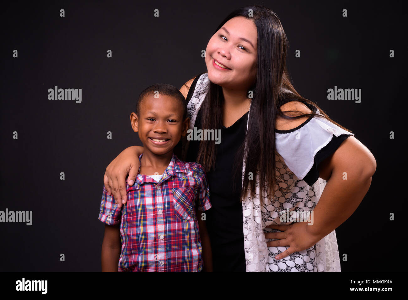 Studio shot of mother and son together against black background Stock Photo