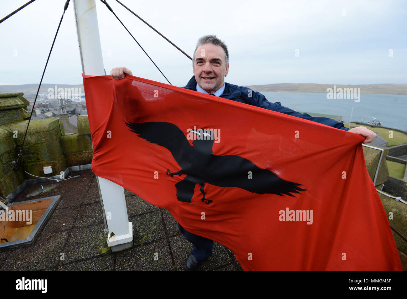 Caretaker of the Lerwick town hall putting up the Raven Banner flag for the Lerwick Up Helly Aa celebrations on the last Tuesday of January Stock Photo