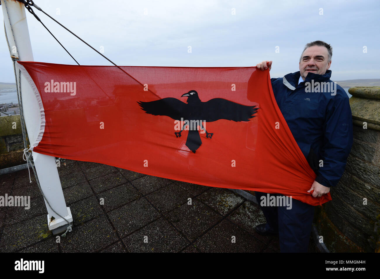 Caretaker of the Lerwick town hall putting up the Raven Banner flag for the Lerwick Up Helly Aa celebrations on the last Tuesday of January Stock Photo
