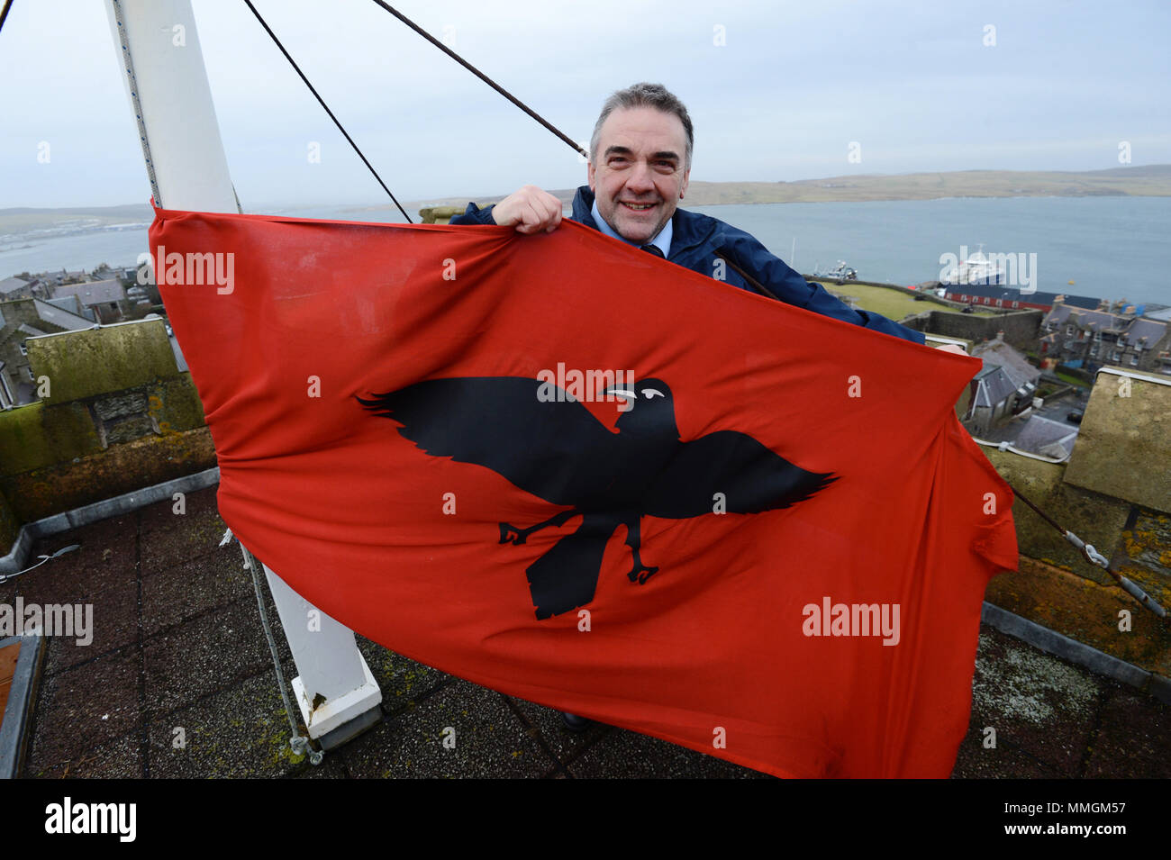 Caretaker of the Lerwick town hall putting up the Raven Banner flag for the Lerwick Up Helly Aa celebrations on the last Tuesday of January Stock Photo