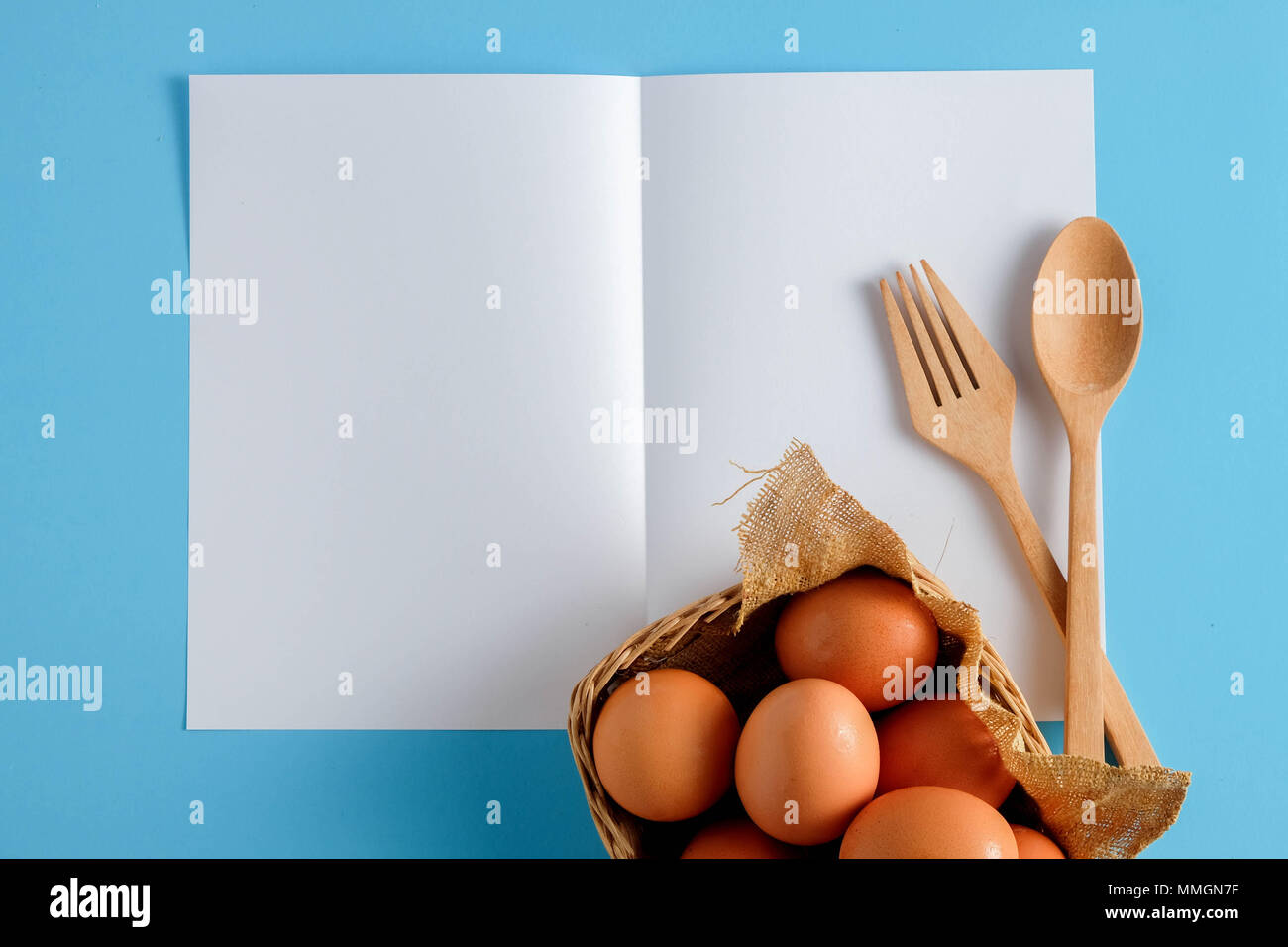 Wooden spoon and white paper on a blue background, for a food menu ...