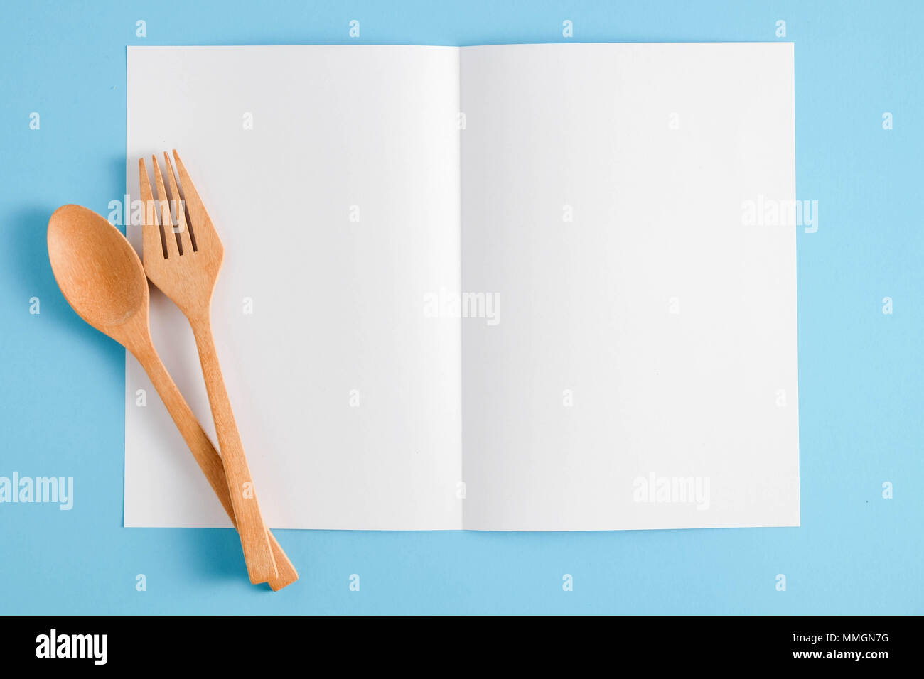 Wooden spoon and white paper on a blue background, for a food menu ...