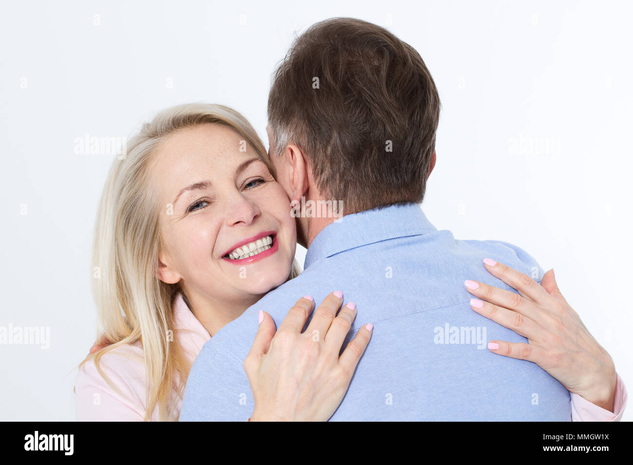Middle aged couple hugging and having fun isolated on white Stock Photo