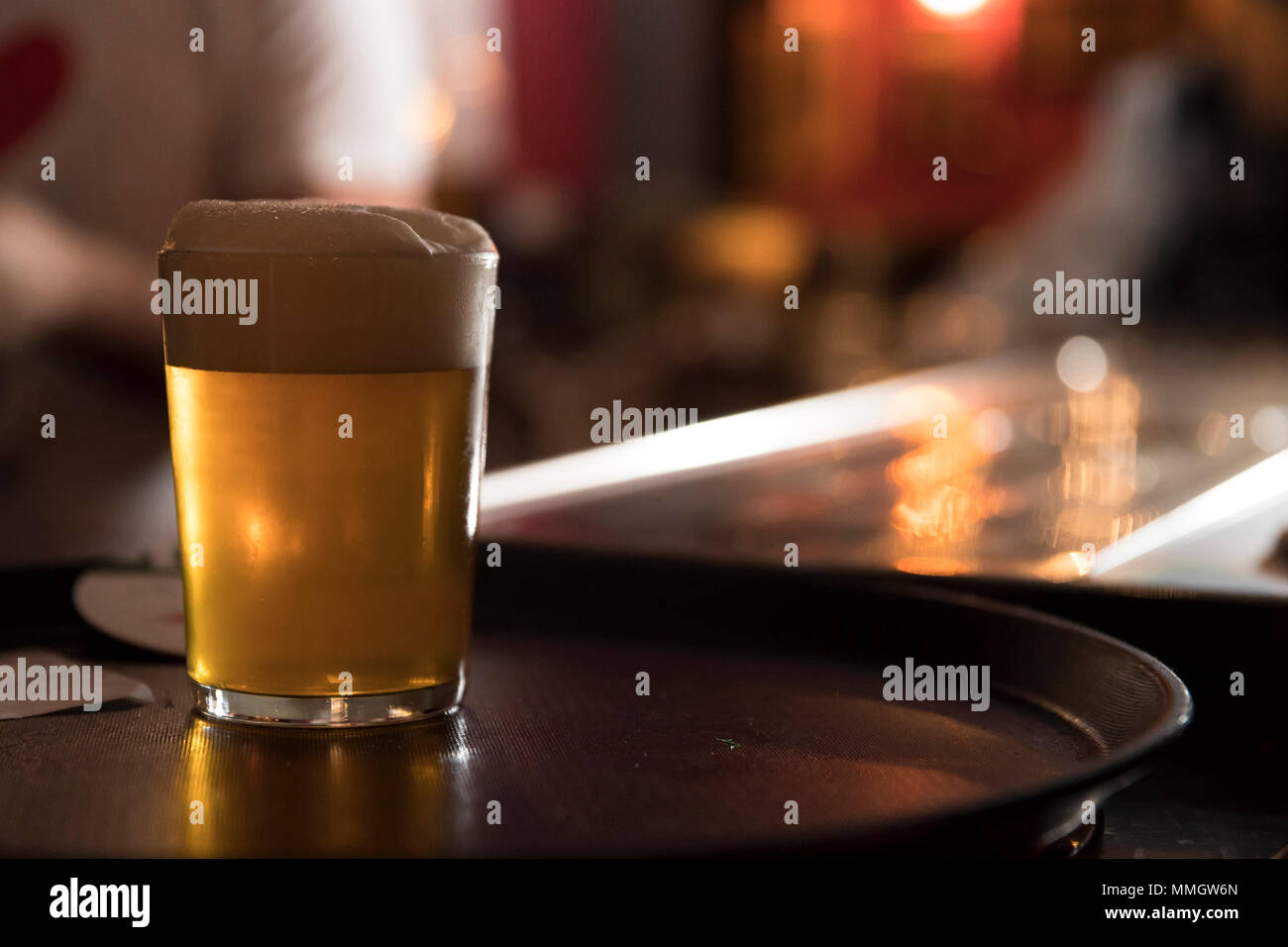 a cold glass of beer on a bar counter, subject on the left Stock Photo