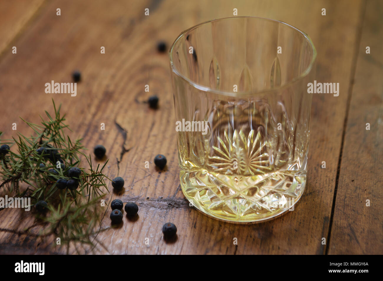 A glass of gin with juniper berries (Juniperus Communis) on a rustic table Stock Photo Alamy