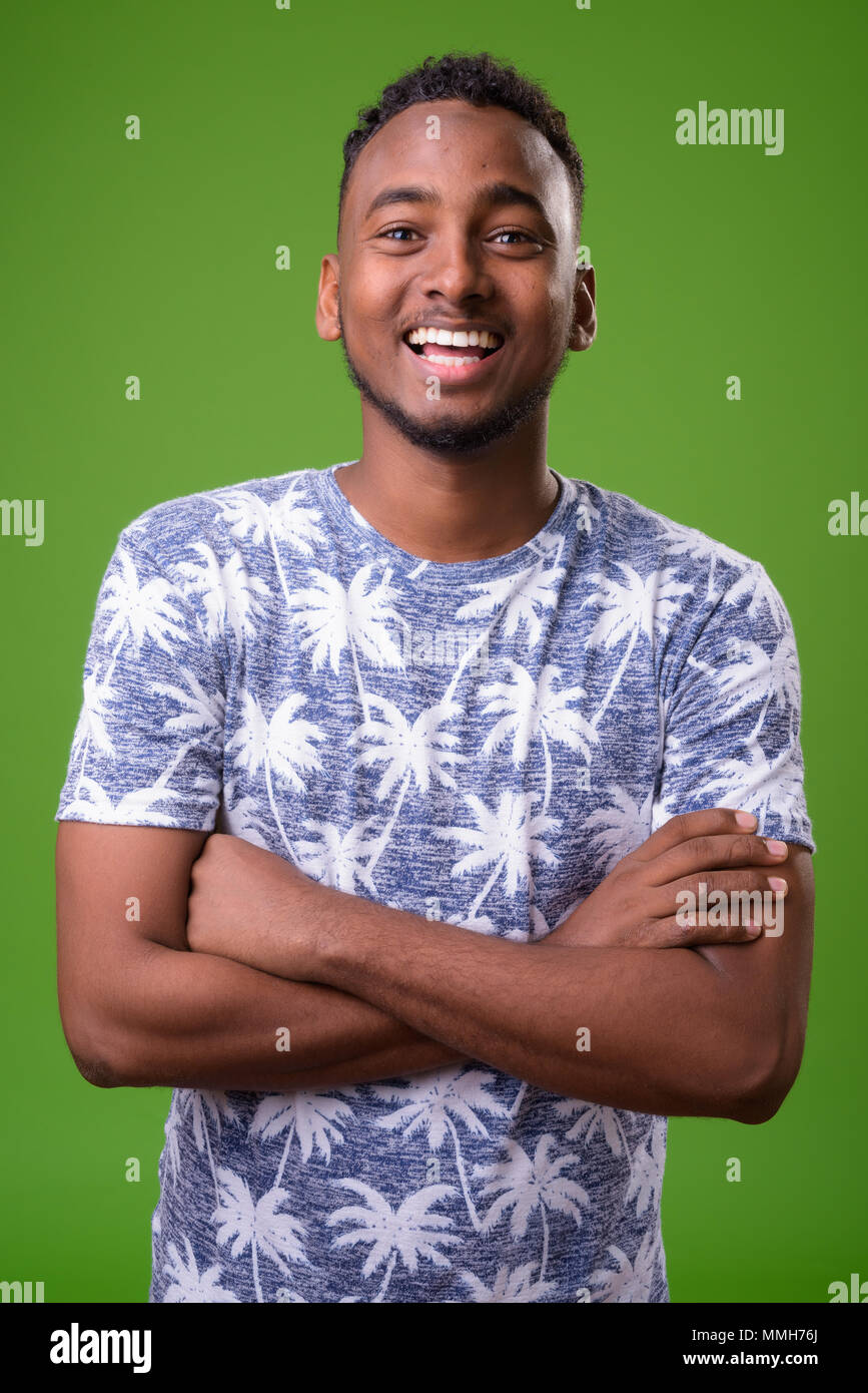 Young handsome African man against green background Stock Photo