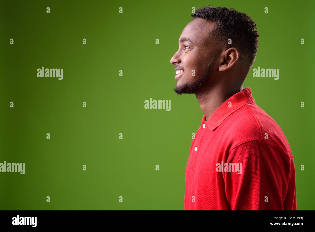 Young handsome African man against green background Stock Photo