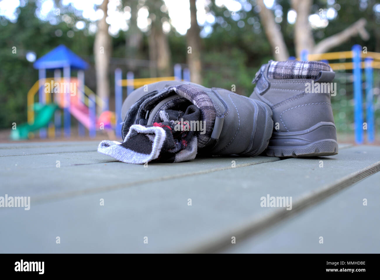 Kid removed pair of boots and socks with children playing on rides in