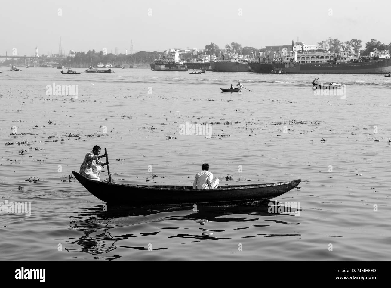 Dhaka, Bangladesh, February 24 2017: Rowing boats on the Buriganga River in Dhaka Bangladesh and in the background the old shipyard Stock Photo