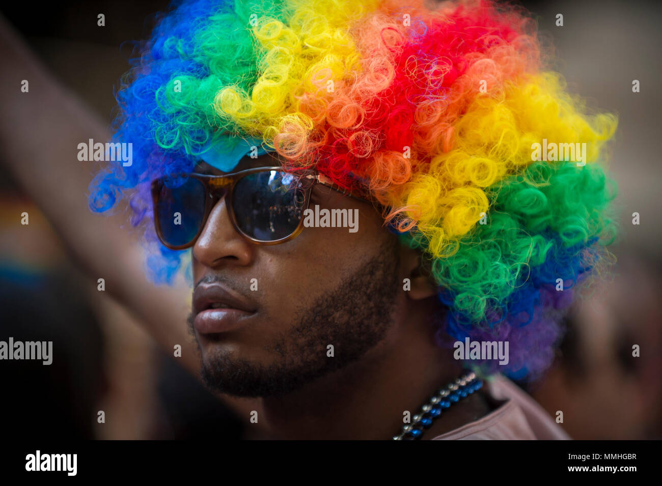 NEW YORK CITY - JUNE 25, 2017: Supporter in a rainbow afro wig on the sidelines of the annual Pride Parade as it passes through Greenwich Village. Stock Photo