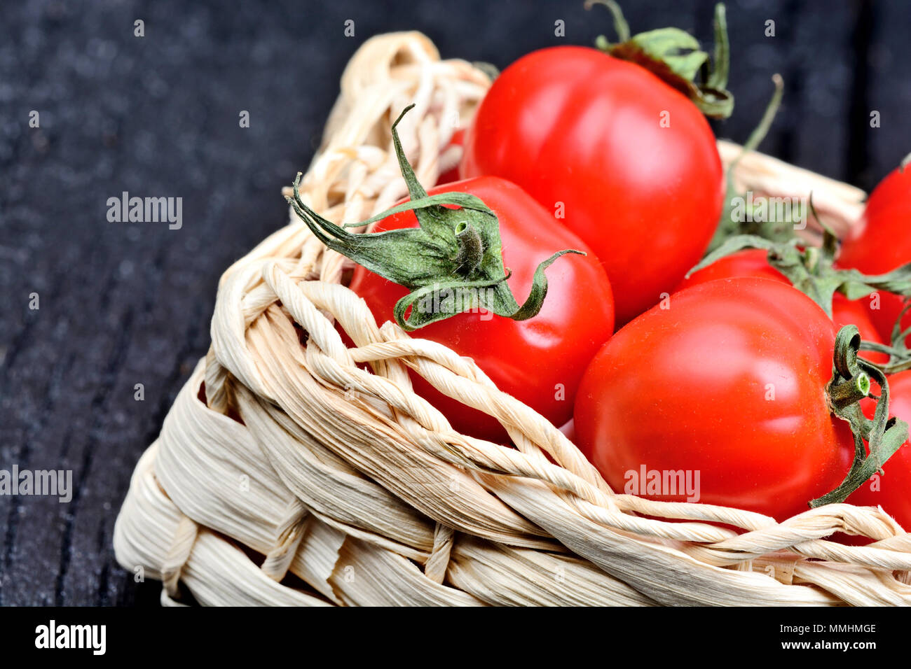 Cherry tomatoes in a rustic wicker on a wood table Stock Photo - Alamy