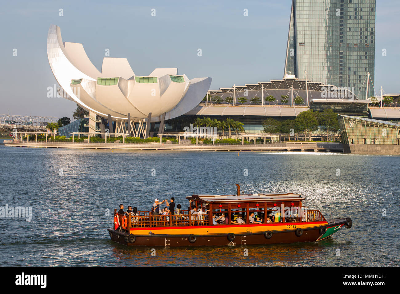 Tourists taking the bum boat touring in-front of Singapore Marina Bay Sands and Art Science Museum. Stock Photo